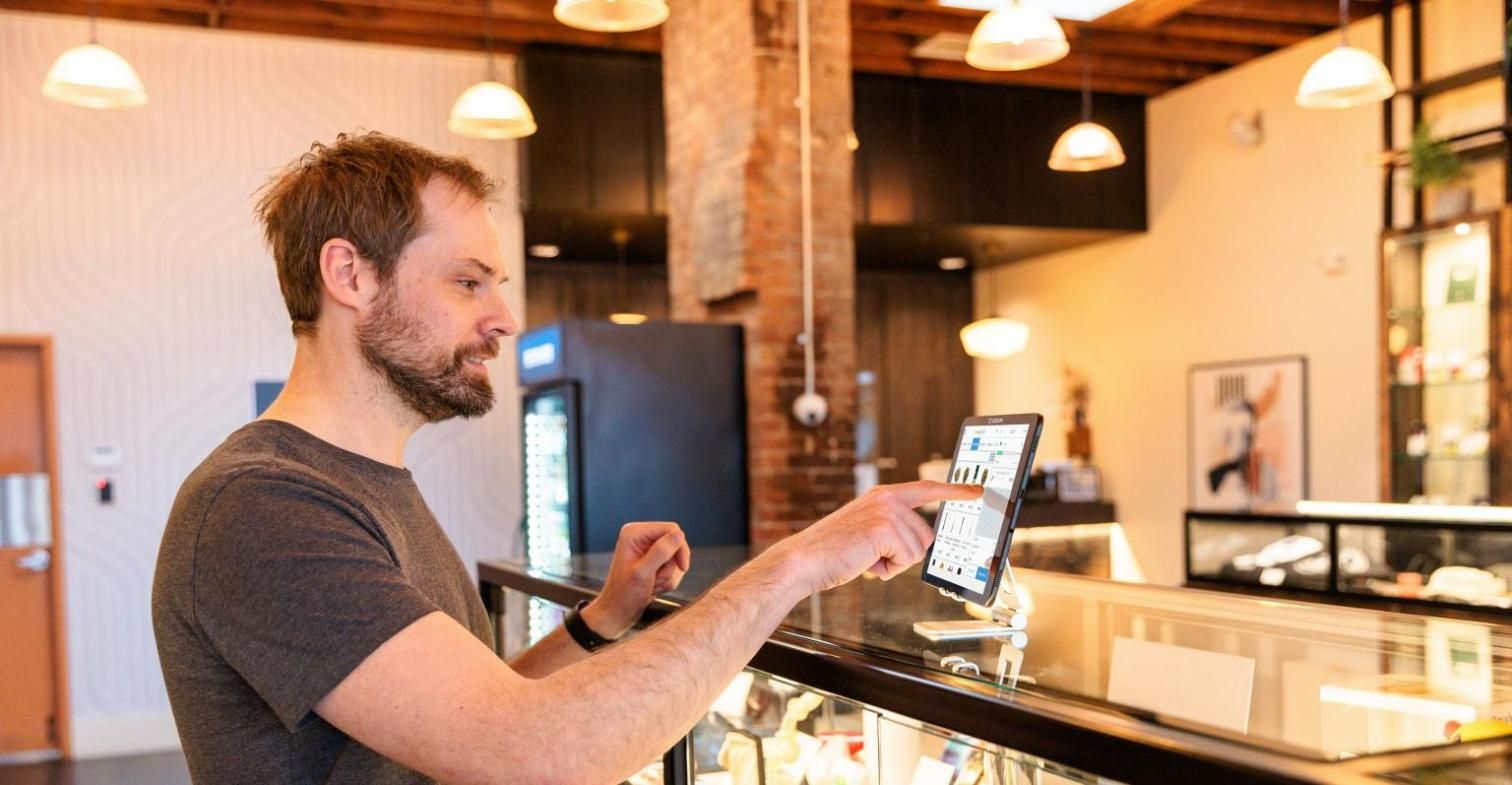 Comerciante usando una tableta en el mostrador de su tienda